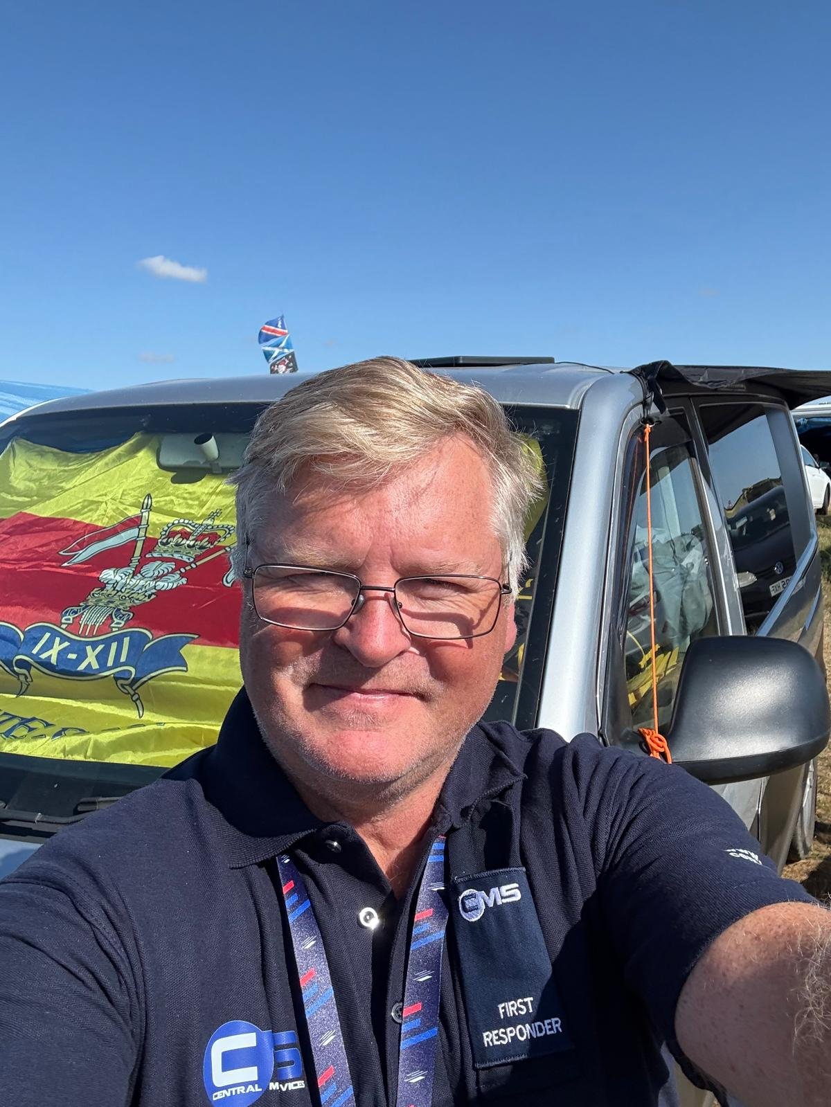 Chris Kent-Ledger on duty as a first responder, with the flag of his former regiment, the 9th/12th Royal Lancers